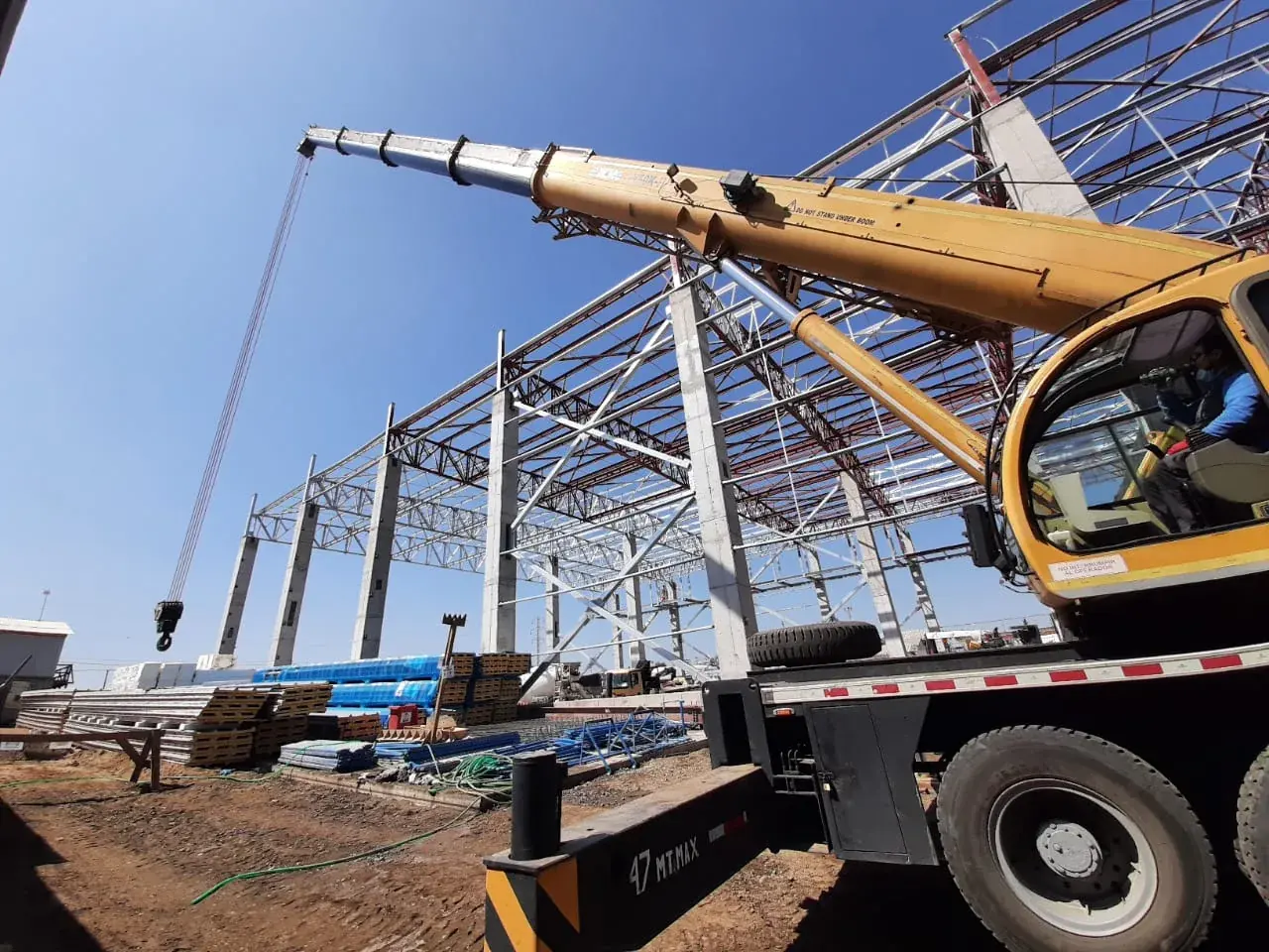 Grúa telescópica montando la estructura metálica de una nave industrial